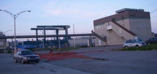 Ice plant with 300 ton travelift in background, guy repairing nets in parking lot!